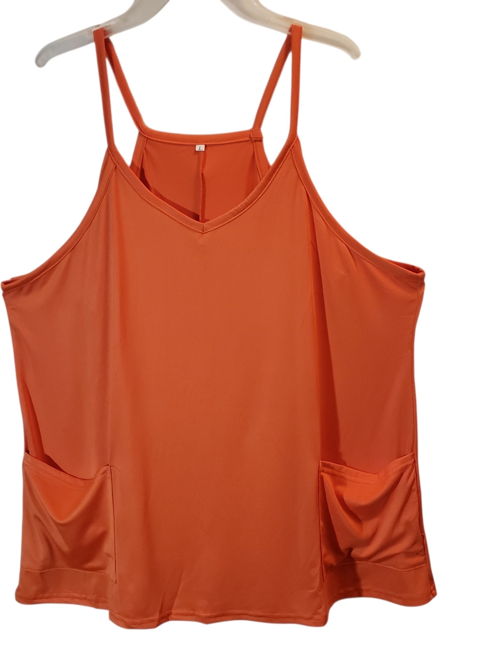 Free people lg movement orange tank-style romper with spaghetti straps.